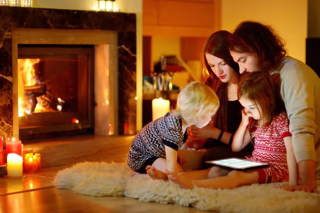 family sitting by the fireside looking at checklist on a tablet