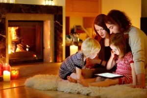 family sitting by the fireside looking at checklist on a tablet